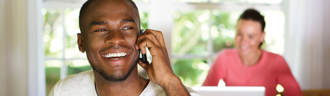 Young, happy black male on the phone.